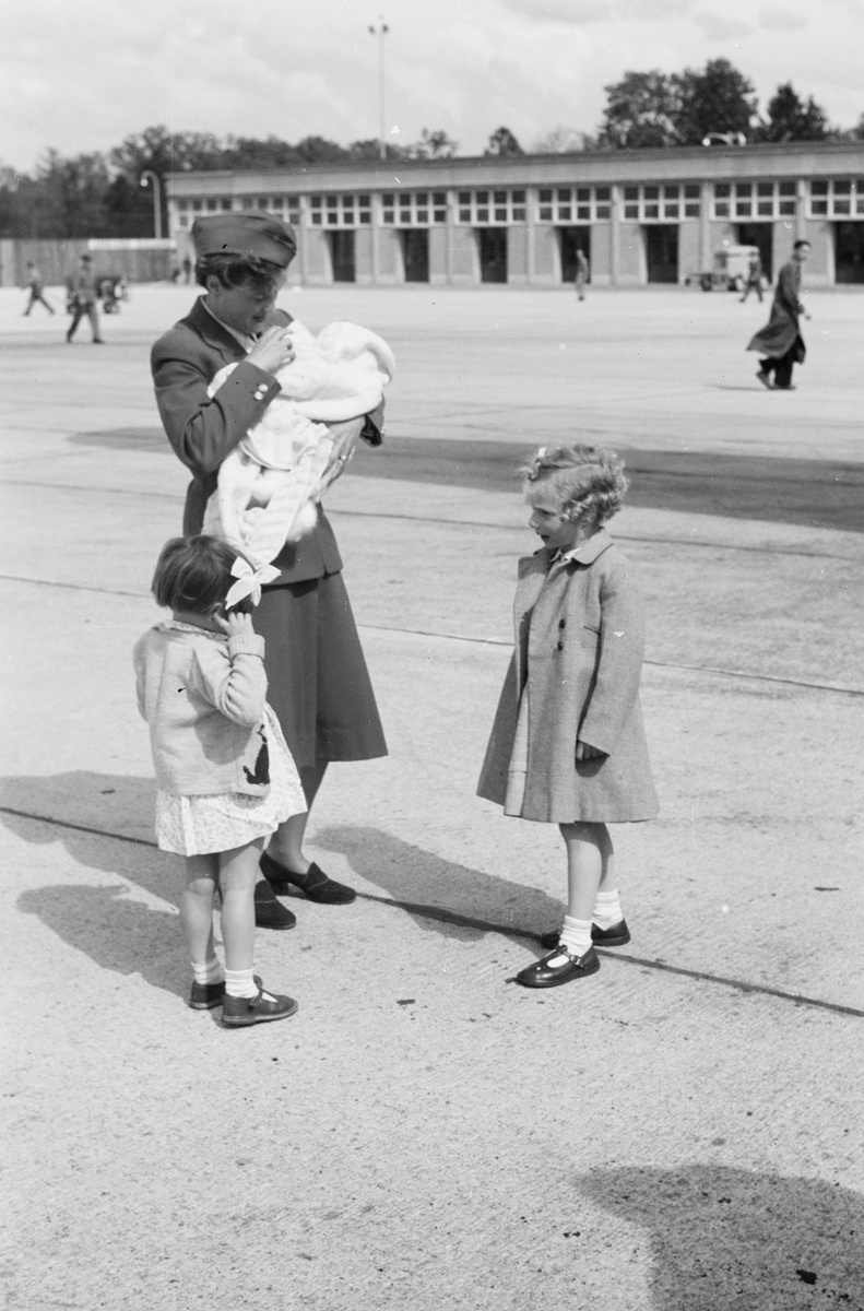 Hostess mit Kindern auf dem Vorfeld des Flughafens Genève-Cointrin